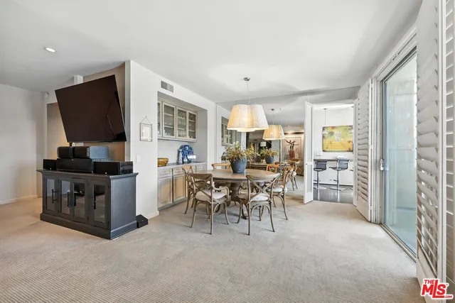 a living room with furniture a flat screen tv and a refrigerator