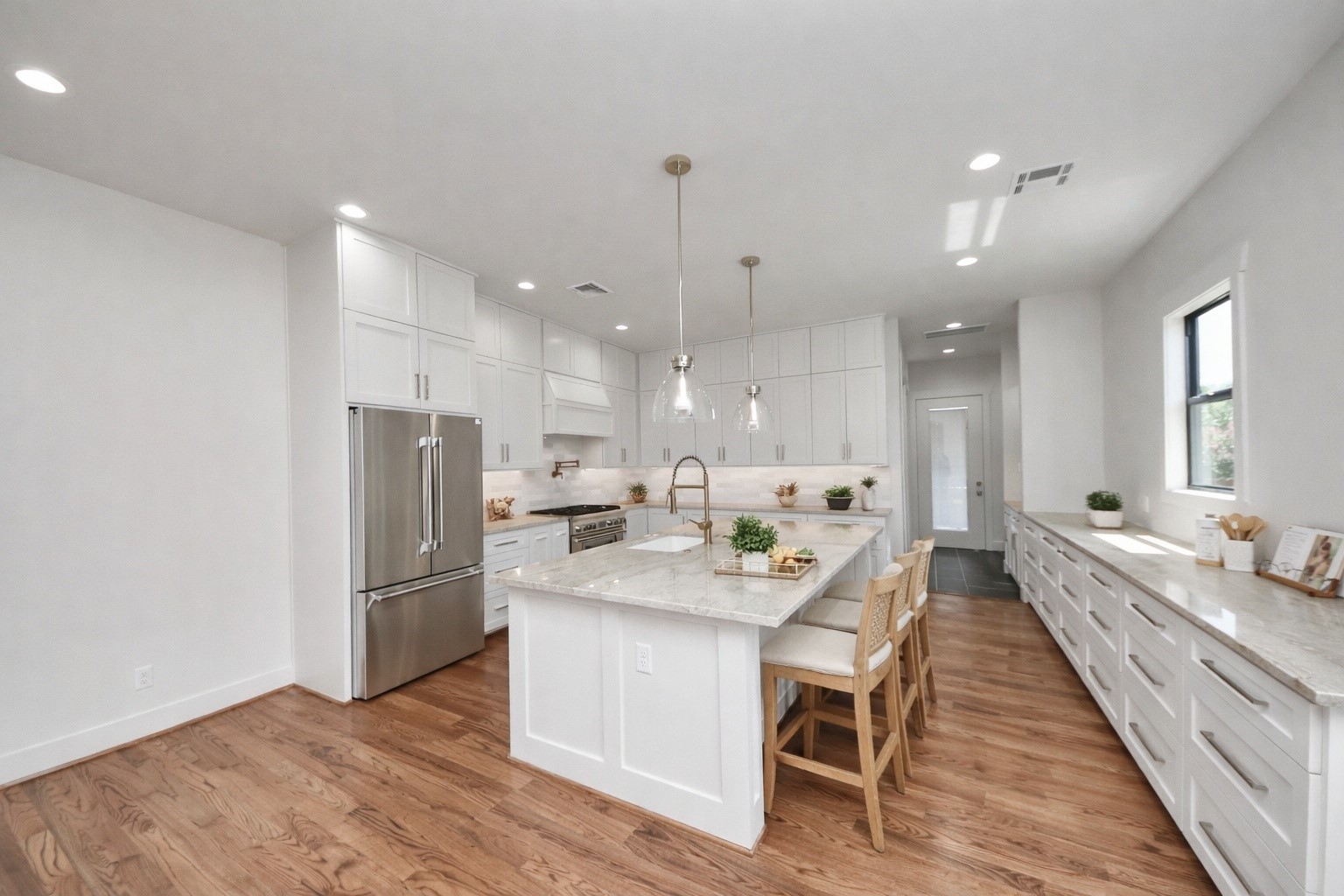 4541 Walker Street Houston, TX 77023 - Photo 9 of 24 a large kitchen with a refrigerator a sink dishwasher a oven and a dining table with wooden floor