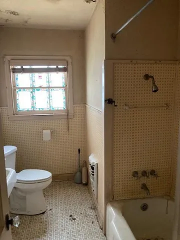 a bathroom with a toilet a sink and shower
