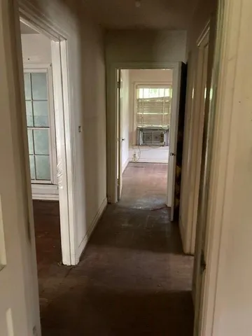 a view of a hallway with wooden floor and a living room