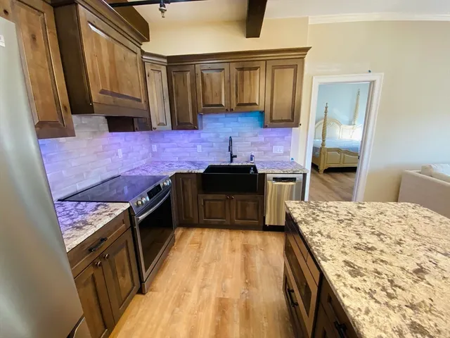 a kitchen with a stove and a wooden floor