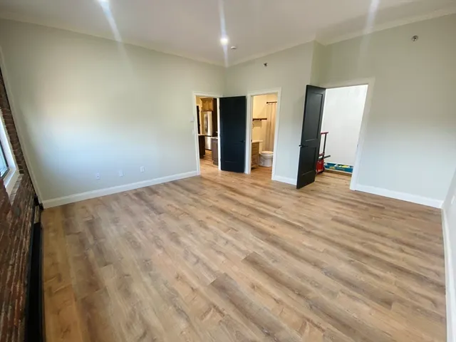 a view of an empty room with wooden floor