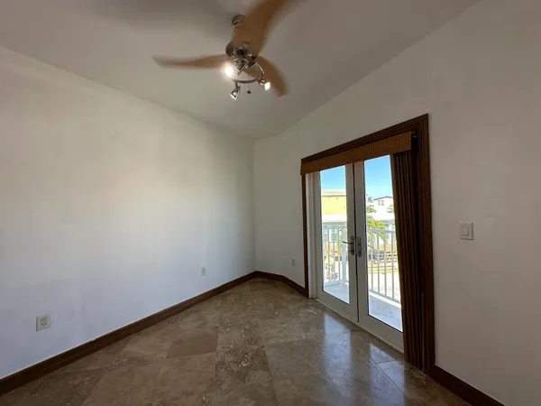 an empty room with closet and a ceiling fan