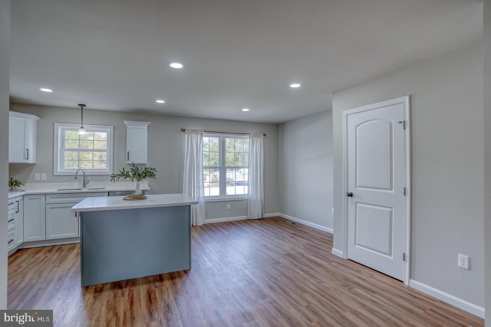 232 Rojan Road, Unit 12 Dover, DE 19901 - Photo 13 of 17 a kitchen with kitchen island wooden floors and stainless steel appliances