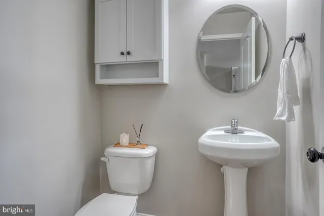 a bathroom with a toilet sink and mirror