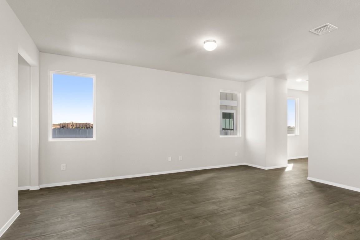 167 Daylily Drive Elgin, TX 78621 - Photo 11 of 29 an empty room with wooden floor and windows
