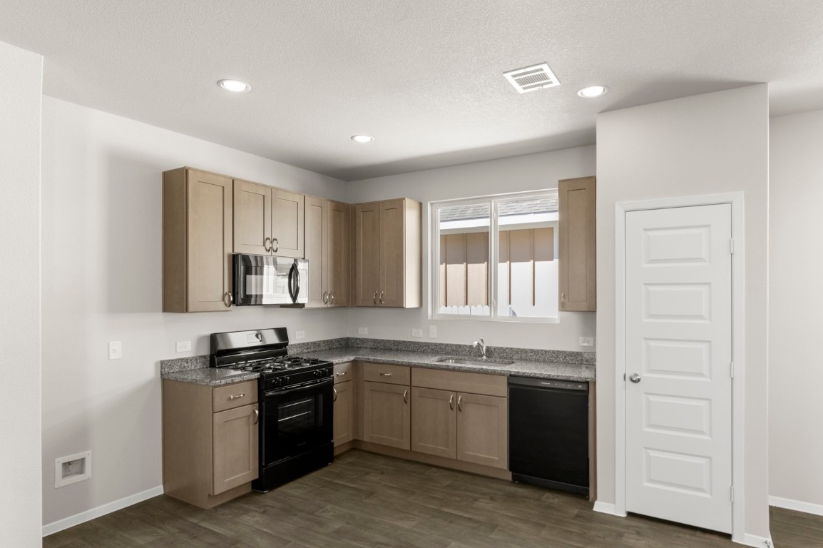 167 Daylily Drive Elgin, TX 78621 - Photo 15 of 29 a kitchen with stainless steel appliances granite countertop a stove and a sink