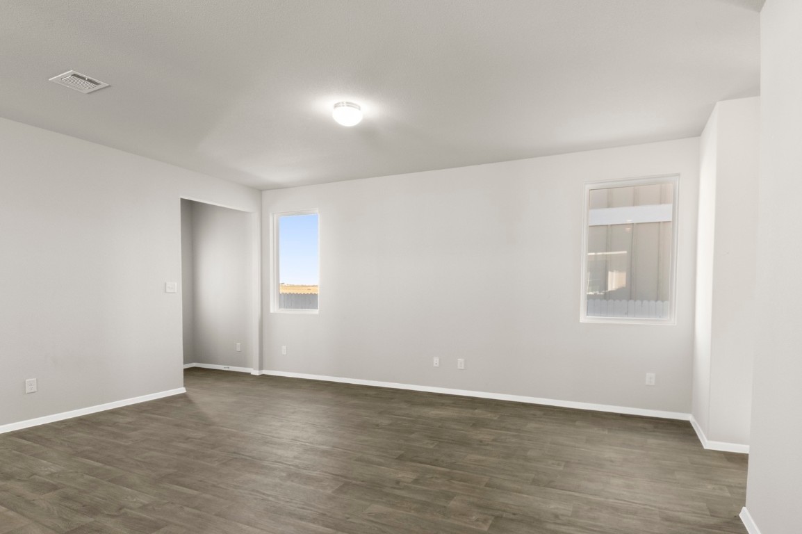 167 Daylily Drive Elgin, TX 78621 - Photo 10 of 29 a view of an empty room with wooden floor and a window