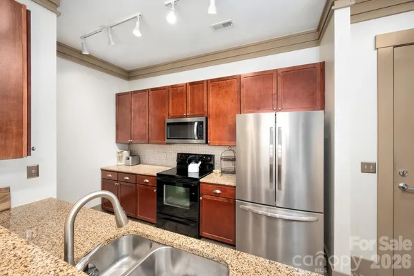 a kitchen with stainless steel appliances granite countertop a refrigerator sink and cabinets