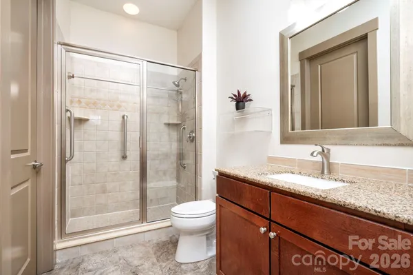 a bathroom with a granite countertop sink toilet and shower