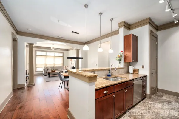 a open kitchen with a sink stove and wooden floor
