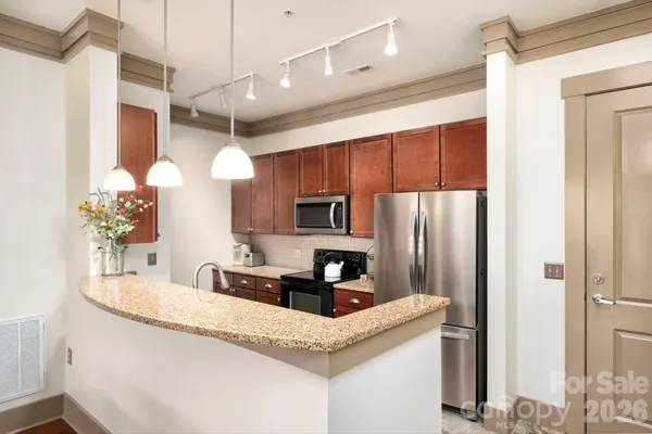 a kitchen with stainless steel appliances granite countertop a sink refrigerator and microwave