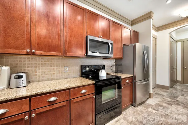 a kitchen with stainless steel appliances granite countertop a refrigerator a stove a sink and dishwasher