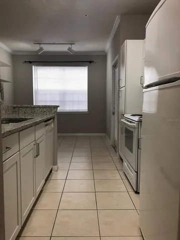 a kitchen with stainless steel appliances granite countertop a sink and a refrigerator