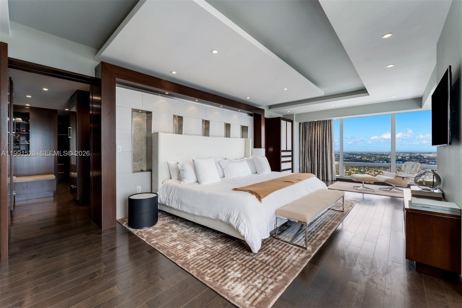 1425 Brickell Avenue, Unit PH2ABCD Miami, FL 33131 - Photo 16 of 20 a spacious bedroom with a large bed and a wooden floor