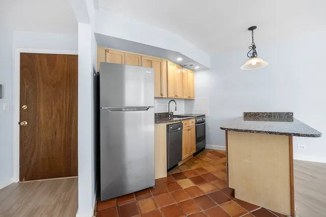 a kitchen with a refrigerator a sink and a window