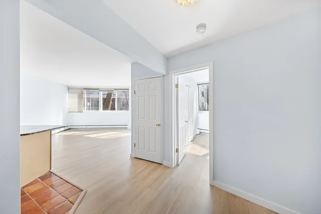 a view of empty room with wooden floor and window