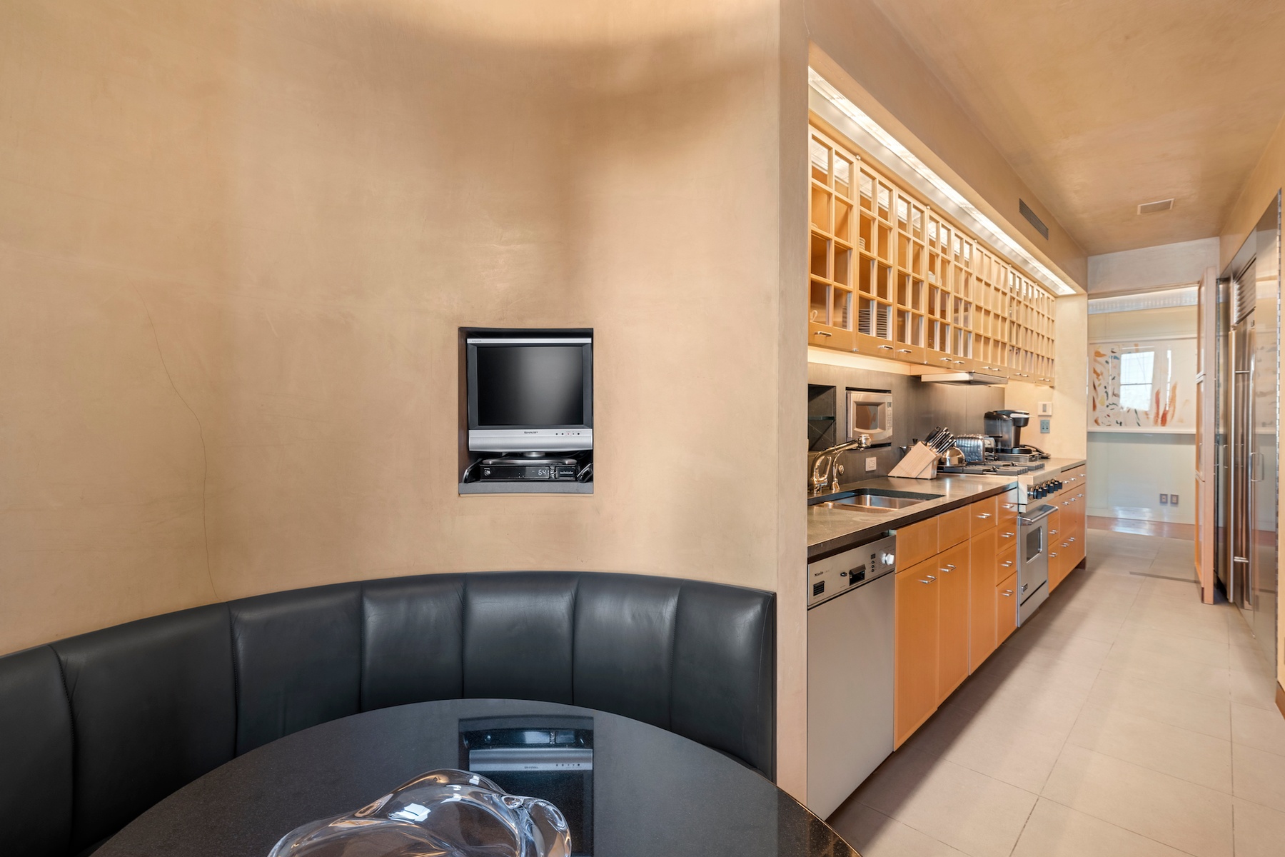 781 5th Avenue, Unit 2001 Manhattan, NY 10022 - Photo 14 of 19 a kitchen with stainless steel appliances wooden cabinets a stove and a refrigerator