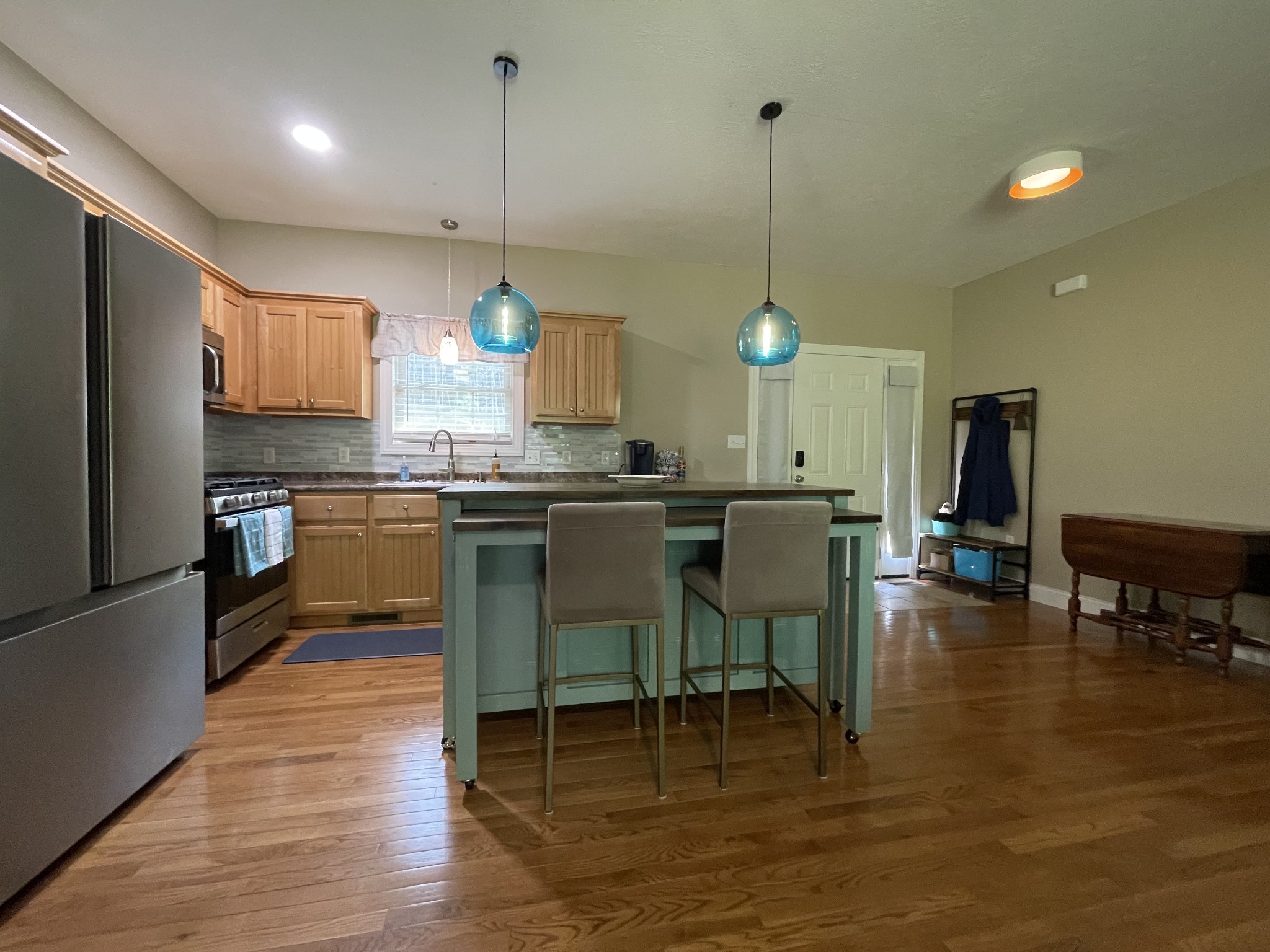 1751 Excalibur Trail Cedar Grove, TN 38321 - Photo 14 of 47 a kitchen with stainless steel appliances granite countertop a stove a refrigerator a kitchen island a dining table and chairs with wooden floor