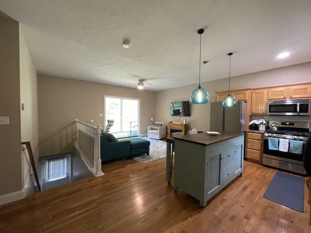 a kitchen with stainless steel appliances granite countertop a stove and a wooden floors