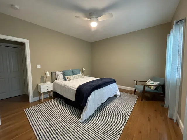 a spacious bedroom with a bed and wooden floor