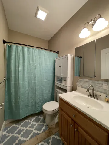 a bathroom with a sink a toilet a mirror and shower