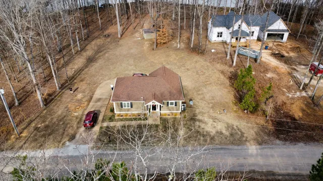 a front view of a house with a yard and trees