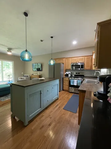 a kitchen with stainless steel appliances granite countertop a sink a stove top oven a counter space and cabinets