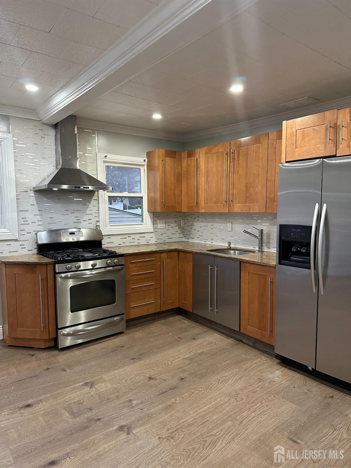 a kitchen with stainless steel appliances granite countertop a stove a sink and a refrigerator