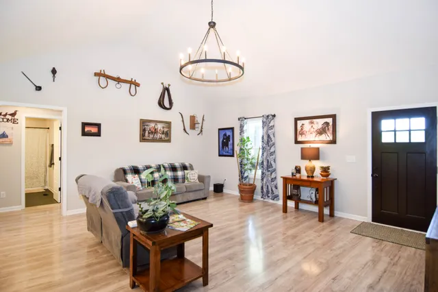 a kitchen with stainless steel appliances a dining table chairs stove refrigerator and microwave