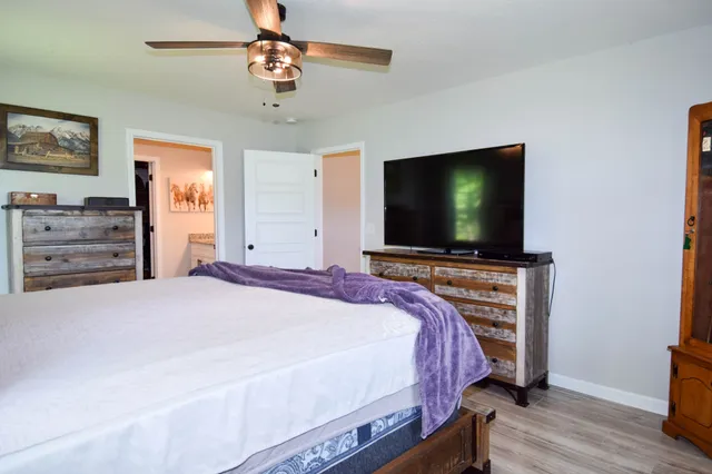 a bedroom with bed and wooden floor