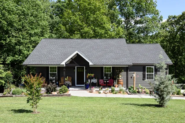 a front view of a house with porch and garden