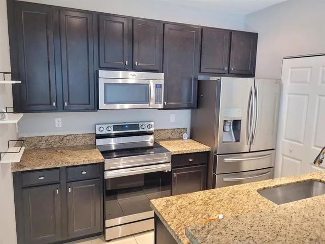 a kitchen with wooden cabinets and a stainless steel appliances