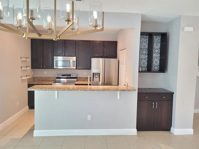 a kitchen with stainless steel appliances granite countertop a sink a stove and a refrigerator