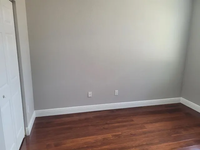 a view of an empty room with wooden floor