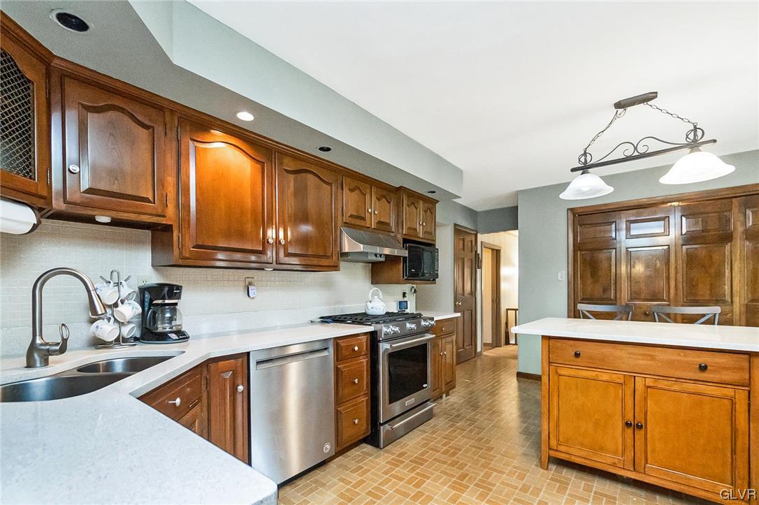 7116 Linden Road Lower Macungie Township, PA 18062 - Photo 11 of 41 a kitchen with stainless steel appliances granite countertop a stove a sink and a microwave