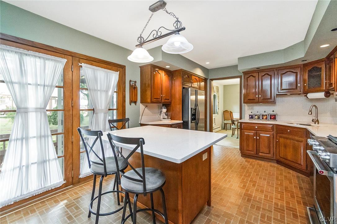 7116 Linden Road Lower Macungie Township, PA 18062 - Photo 6 of 41 a open kitchen with stainless steel appliances granite countertop a stove top oven a refrigerator a sink dishwasher a dining table and chairs with wooden floor