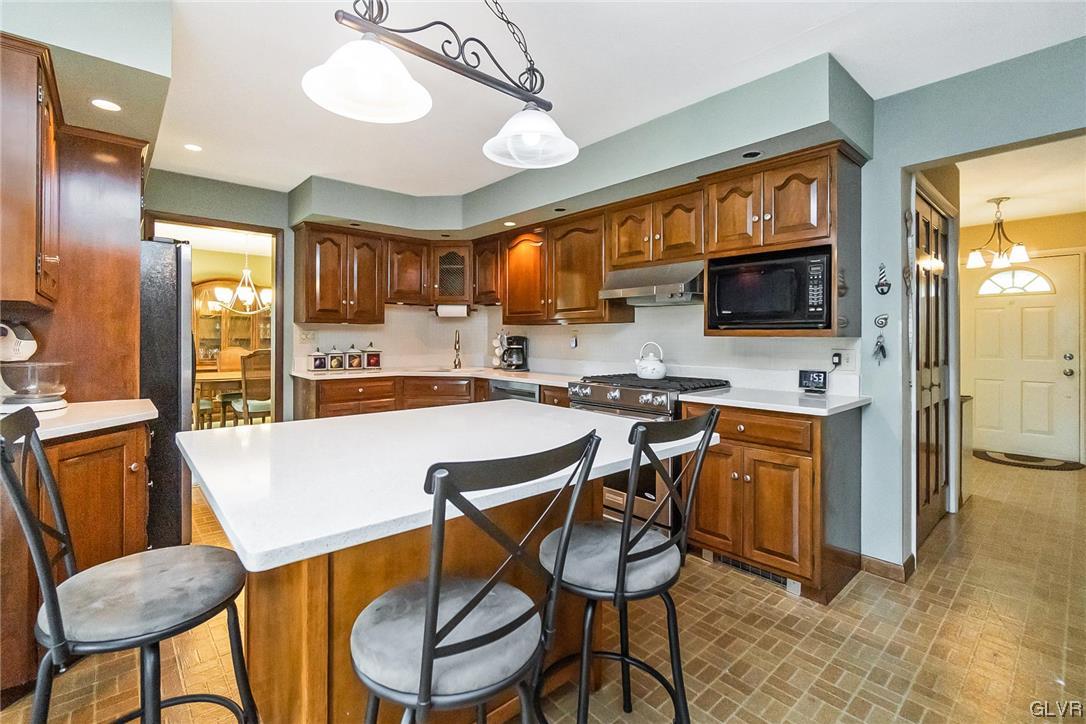 7116 Linden Road Lower Macungie Township, PA 18062 - Photo 7 of 41 a kitchen with stainless steel appliances kitchen island granite countertop a table chairs sink and cabinets
