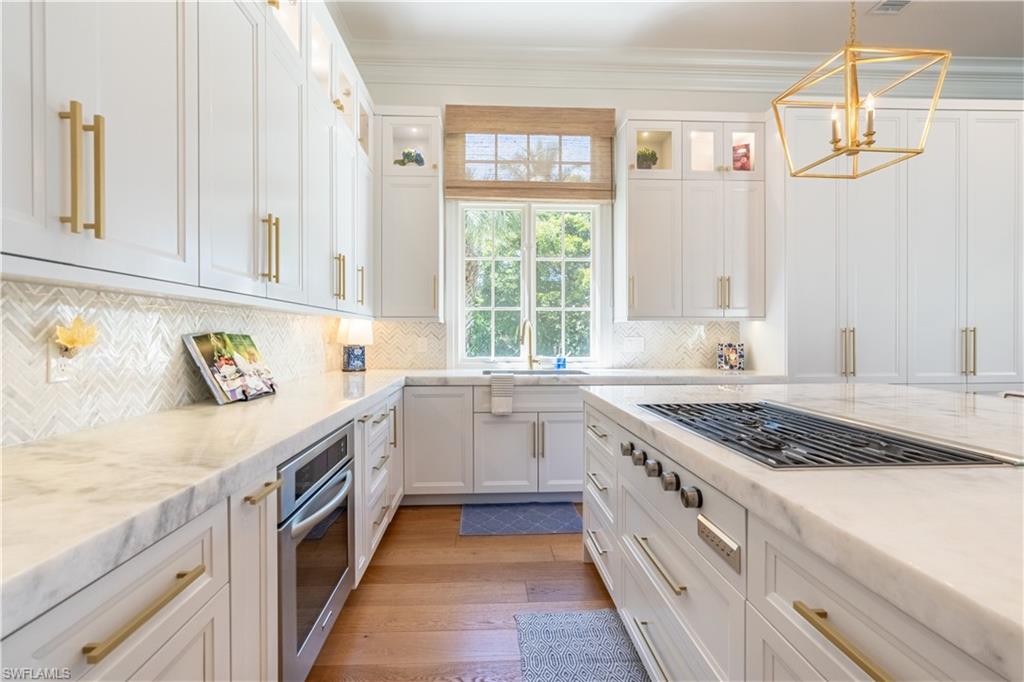 2125 Modena Court Naples, FL 34105 - Photo 16 of 50 a kitchen with granite countertop white cabinets and white appliances
