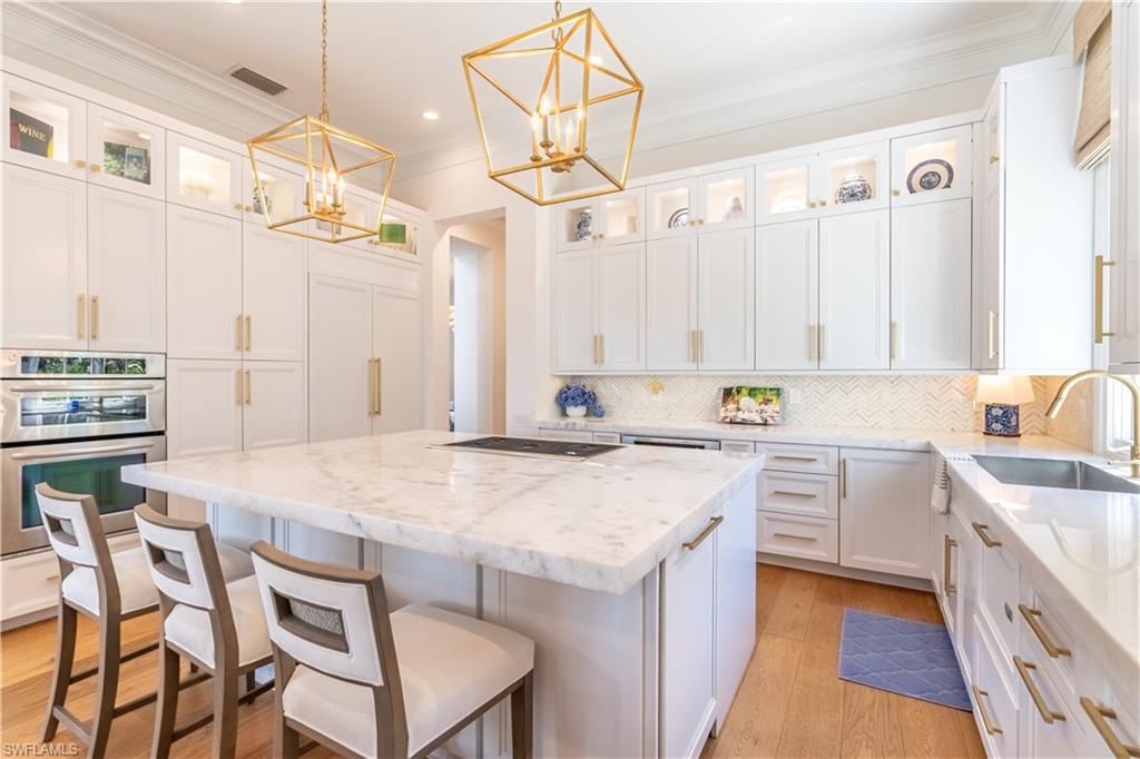 2125 Modena Court Naples, FL 34105 - Photo 17 of 50 a kitchen with a table chairs sink and cabinets
