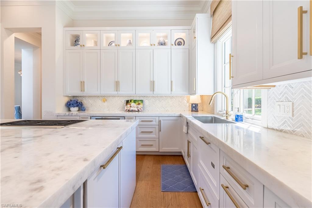 2125 Modena Court Naples, FL 34105 - Photo 18 of 50 a kitchen with granite countertop white cabinets and white appliances