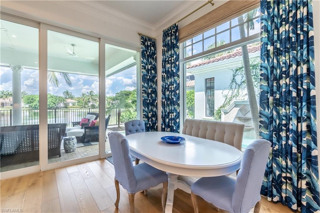 2125 Modena Court Naples, FL 34105 - Photo 19 of 50 a view of a dining room with furniture large windows and wooden floor