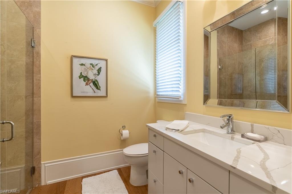 2125 Modena Court Naples, FL 34105 - Photo 24 of 50 a bathroom with a granite countertop sink mirror vanity and toilet