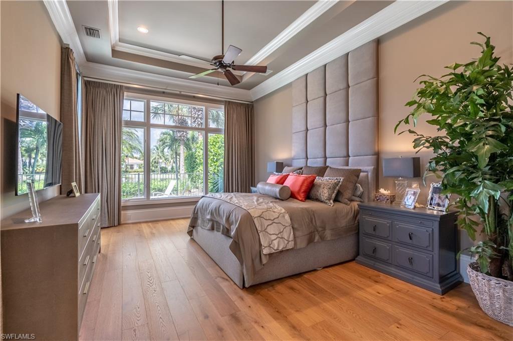 2125 Modena Court Naples, FL 34105 - Photo 25 of 50 a bedroom with a large bed and a chandelier