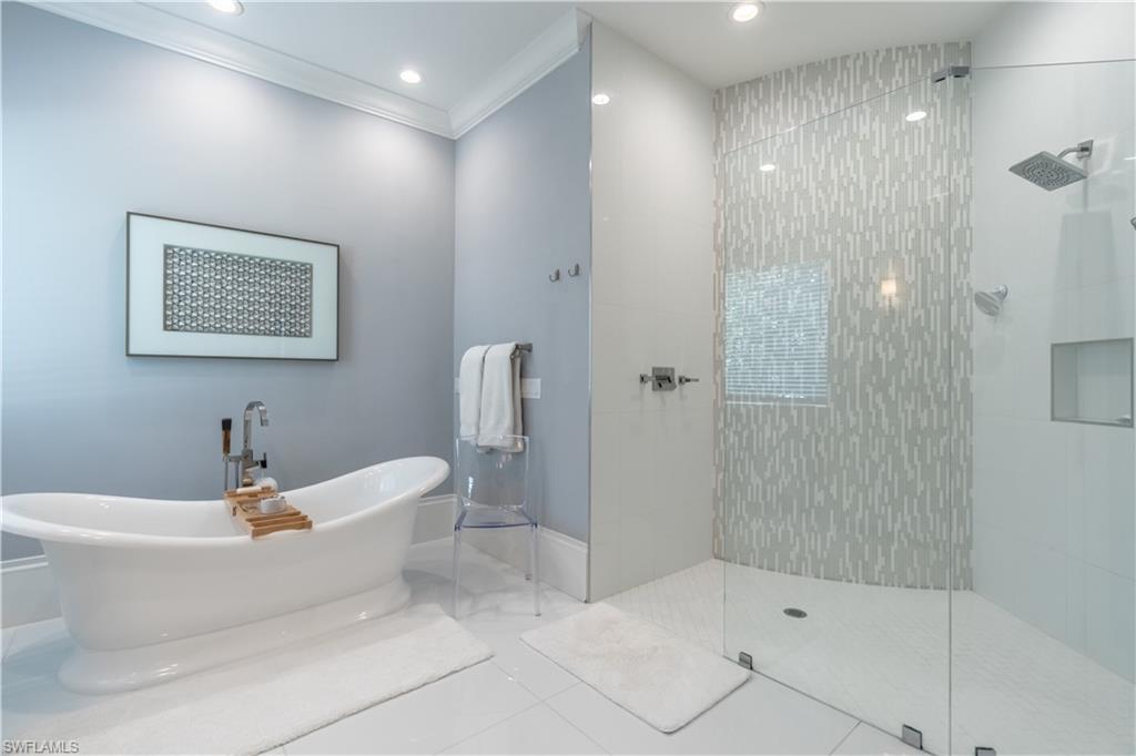 2125 Modena Court Naples, FL 34105 - Photo 27 of 50 a bathroom with a bathtub and a shower