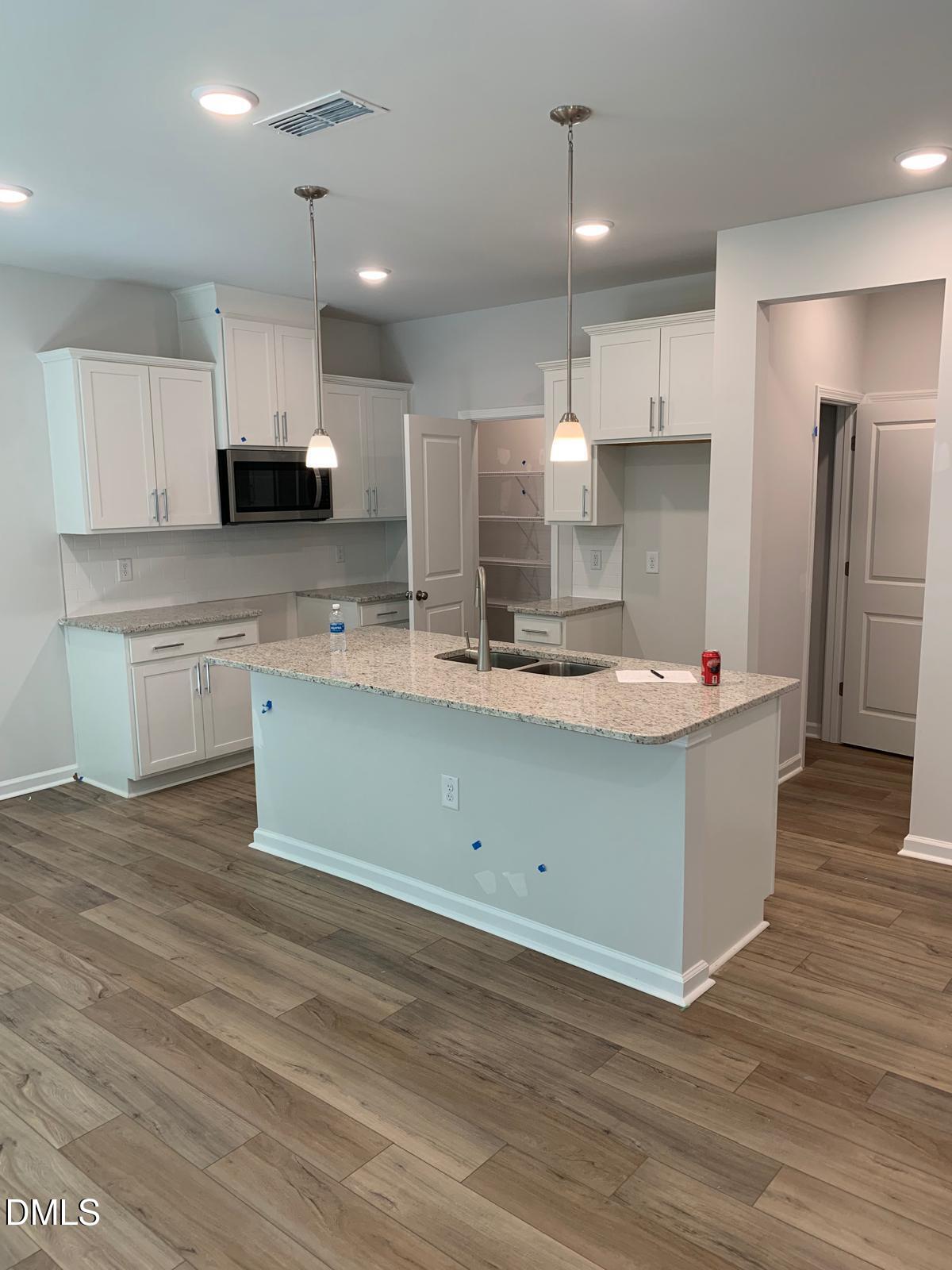 233 Broomside Avenue Raleigh, NC 27603 - Photo 5 of 18 a kitchen with stainless steel appliances kitchen island granite countertop a sink a stove and cabinets