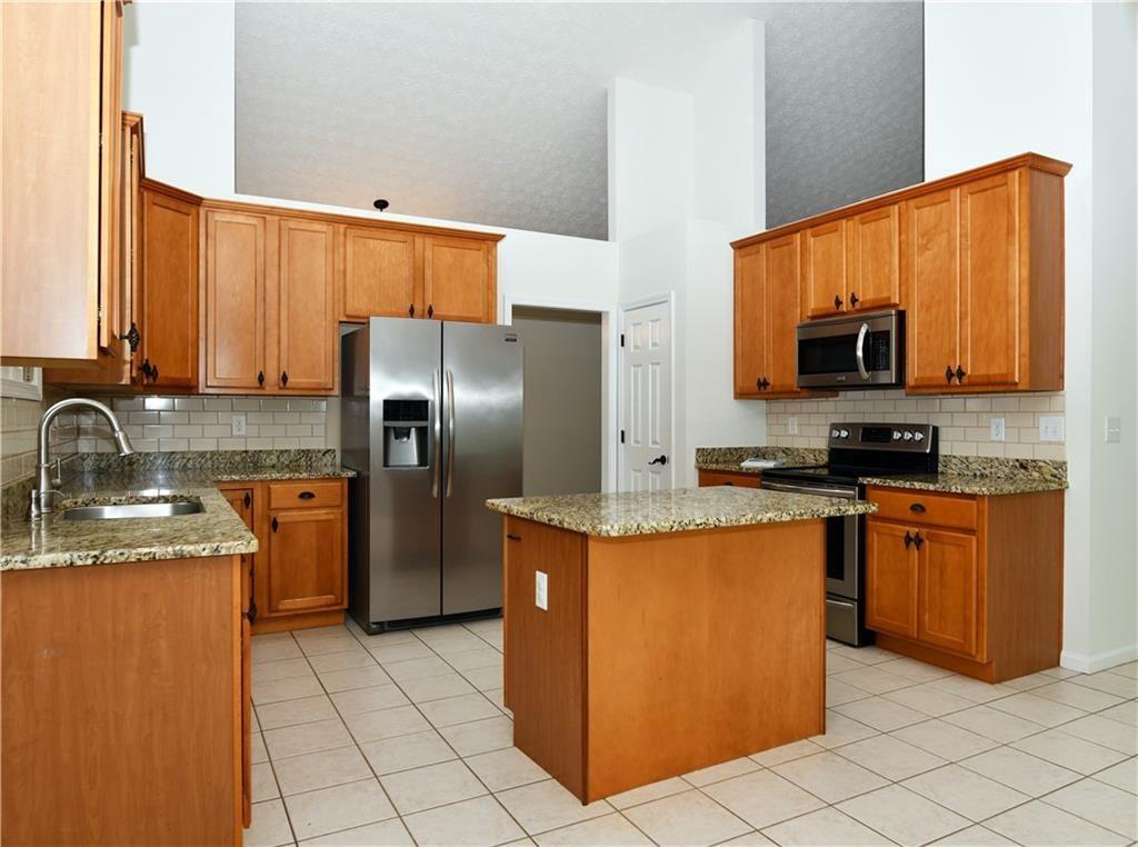 795 Sunset Ridge Lane Southeast Lawrenceville, GA 30045 - Photo 2 of 47 a kitchen with stainless steel appliances granite countertop a sink stove and refrigerator
