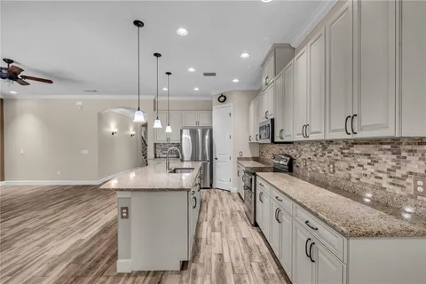 a bathroom with a granite countertop sink a toilet and shower