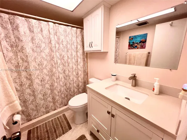 a bathroom with a sink toilet and a mirror