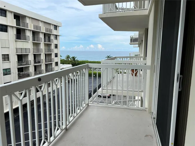 a view of a balcony with wooden floor and fence